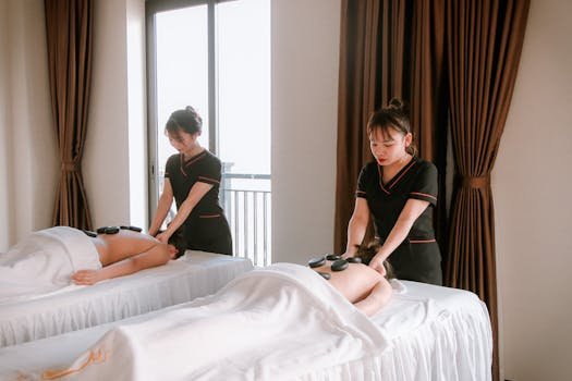 A serene scene of a woman receiving a hot stone massage in a spa, creating a calming atmosphere.